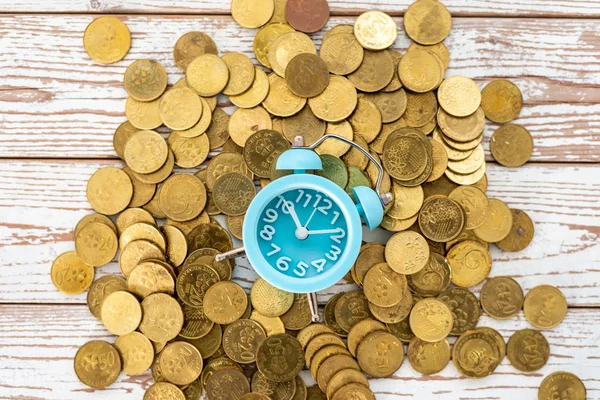 Ahorros para el futuro. Malasia monedas y reloj en respaldo de madera — Foto de Stock