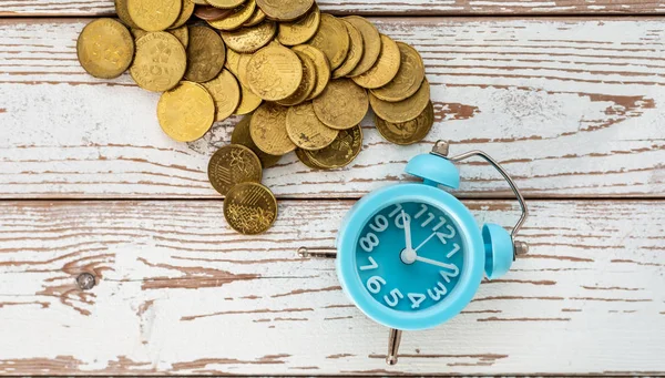 Ahorros para el futuro. Malasia monedas y reloj en respaldo de madera — Foto de Stock