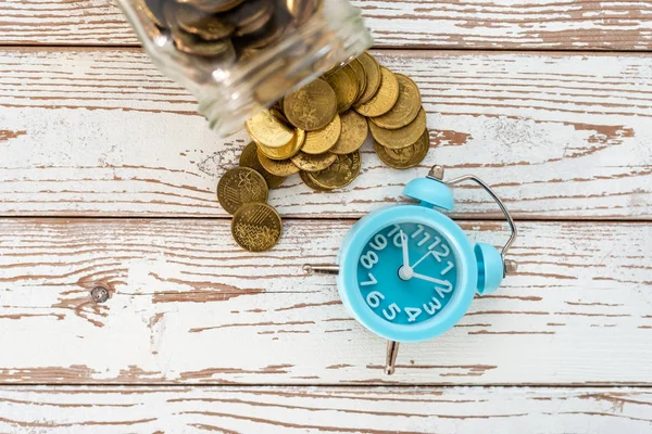 Ahorros para el futuro. Malasia monedas y reloj en respaldo de madera — Foto de Stock