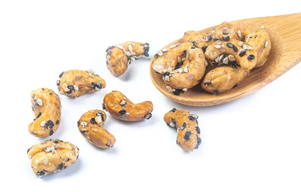 Sezamový křídový kešú ořechy na dřevěné lžičce. Izolovaný na bílém b — Stock fotografie