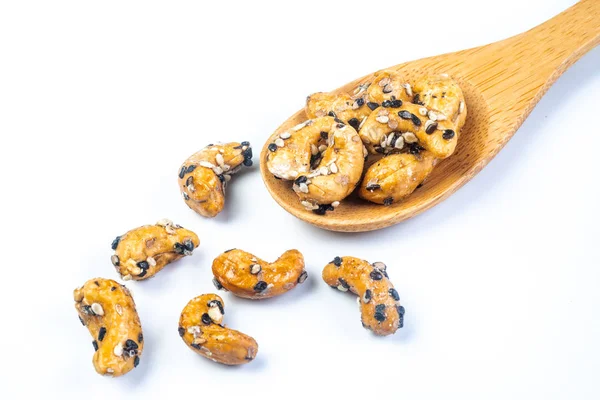 Sezamový křídový kešú ořechy na dřevěné lžičce. Izolovaný na bílém b — Stock fotografie