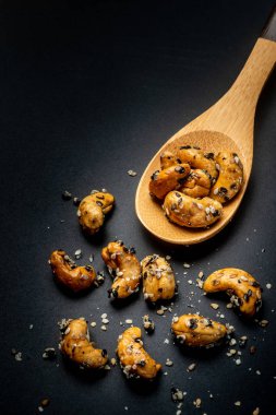 Ahşap Kaşık susam kaplı Kaju fındık. Siyah BAC üzerinde izole