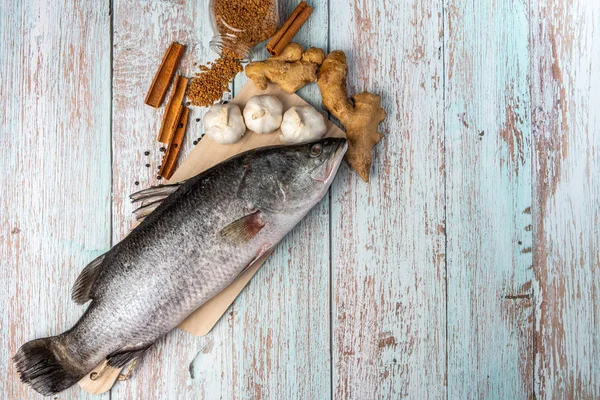 Fresh Sea Bass on wooden table — Stock Photo, Image