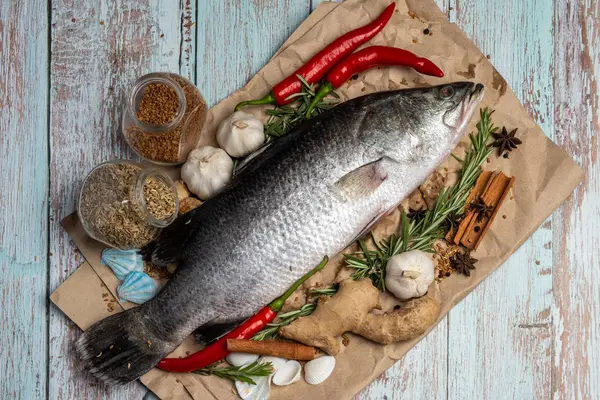 Fresh Raw Sea Bass on wooden table surrounded by fresh ingredien — Stock Photo, Image