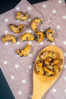 Ahşap Kaşık ve Serviette susam kaplı Kaju fındık. Siyah b