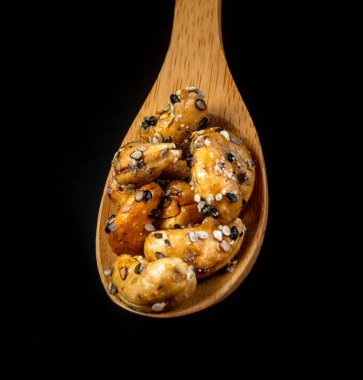 Ahşap Kaşık susam kaplı Kaju fındık. Siyah BAC üzerinde izole