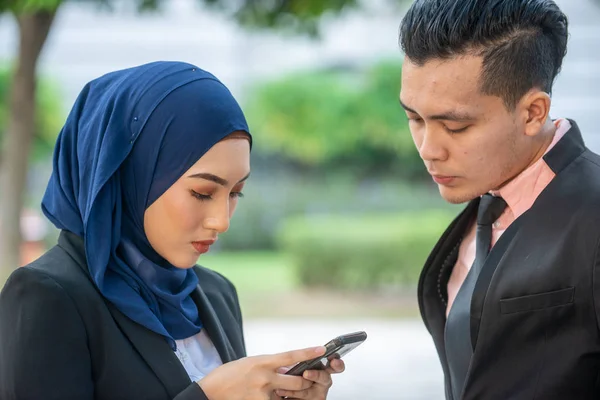 stock image Muslim Couple on their smartphone. Texting and checking out thei