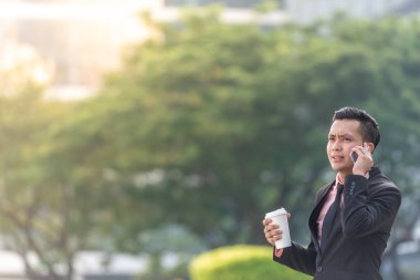 Bir fincan kahve ile onun Smartphone genç Malay Iş adam.