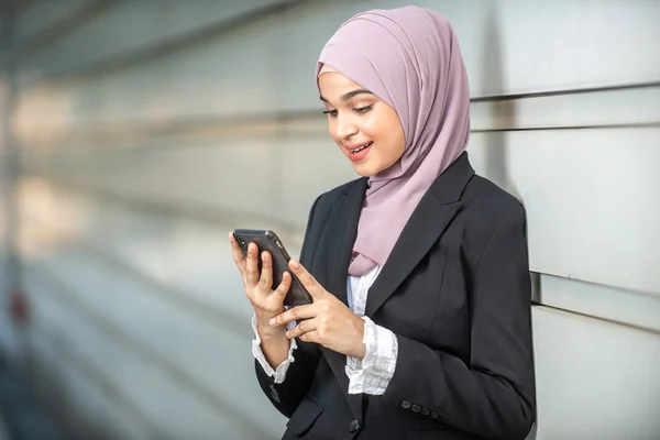 Joven emprendedora musulmana mirando su smartphone. Shal. — Foto de Stock