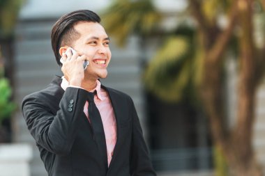 Genç Malay İş Adamı Onun Smartphone konuşuyor. 