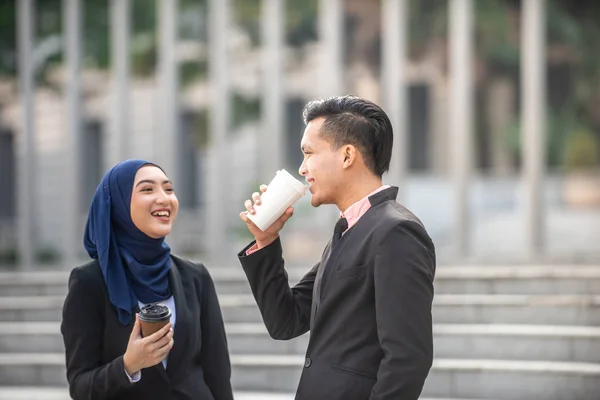 Muslim Businessman and Businesswoman having a conversation durin