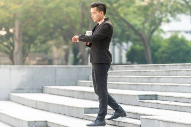 Bir fincan kahve ile onun Smartphone genç Malay Iş adam.