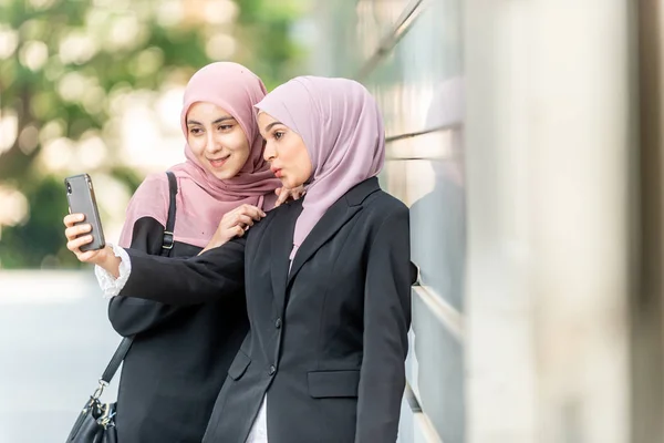 Chicas musulmanas asiáticas tomando una selfie. Ajuste exterior . — Foto de Stock