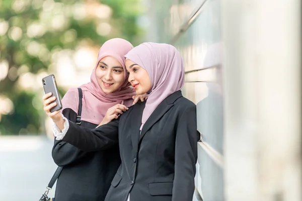 Chicas musulmanas asiáticas tomando una selfie. Ajuste exterior . — Foto de Stock