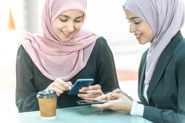 Empresarias musulmanas con su smartphone durante su café b — Foto de Stock