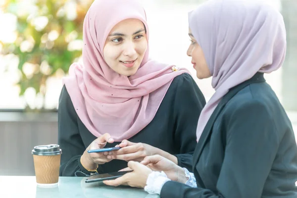 Empresarias musulmanas con su smartphone durante su café b — Foto de Stock