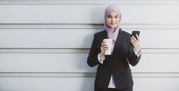 Trabajadora musulmana con su smartphone durante su pausa para el café — Foto de Stock