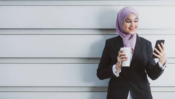Trabajadora musulmana con su smartphone durante su pausa para el café — Foto de Stock