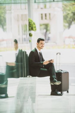 İş Seyahati Taksi Bekliyor. Akıllı telefonuyla oynuyor