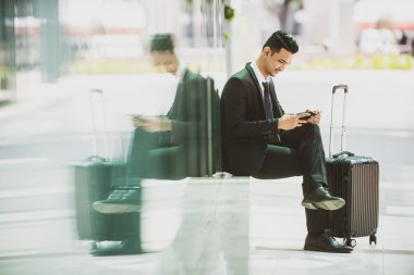 İş Seyahati Taksi Bekliyor. Akıllı telefonuyla oynuyor