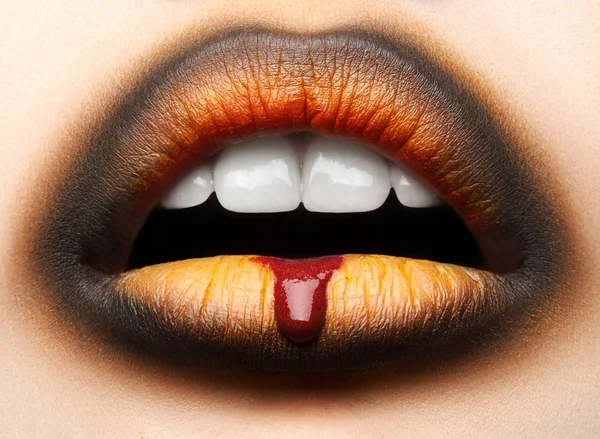 マクロやクローズ アップの創造的なメイクアップ テーマ 黒とオレンジの口紅と滴の血 ハロウィーン 美しい女性の唇は 写真を補正 — ストック写真