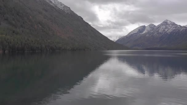 Jeune femme assise sur une vieille jetée au bord du lac de montagne et boissons — Video