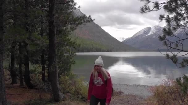 Giovane femmina single sulla riva di un lago di montagna. Colpo di droni . — Video Stock
