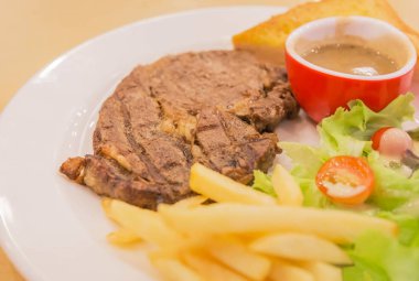 Izgara Kızartma domuz sığır eti biftek ile kızarmış patates ve sebze patates beyaz plaka üzerinde kapatın