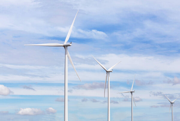 white wind turbines generating electricity in wind power station alternative renewable energy from nature under blue sky 