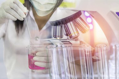 Bilim adamı kadın araştırma araştırma deneyler için mikroskop ekipman ile kimya sıvı taşıyan yakından çift pozlama test tüpü bilim laboratuvarı
