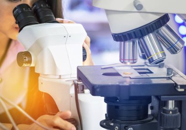 Bilim adamı kadın bilim laboratuvar mikroskop aramak ile mikroskop ekipmanların araştırma deneyler için yakın