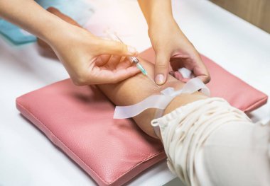 Hastanedeki kan testi için hastanın koluna şırınga enjekte ediliyor.