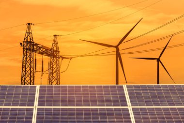        güneş hücreleri ve rüzgar türbinleri günbatımı zamanında doğal alternatif yenilenebilir enerji santrali elektrik yüksek gerilim elektrik pilon ile üretme.   