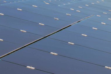 Close up array of  thin film solar cells or amorphous silicon solar cells or photovoltaics in solar power plant turn up skyward absorb the sunlight from the sun  clipart