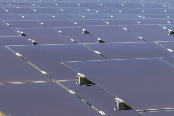 Close up array of  thin film solar cells or amorphous silicon solar cells or photovoltaics in solar power plant turn up skyward absorb the sunlight from the sun