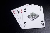 ACE, čtyři z druhu poker karty na černém pozadí.