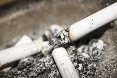 arka plan olarak sigara izmaritleri ve kül görünümünü kapat