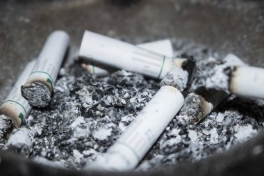 arka plan olarak sigara izmaritleri ve kül görünümünü kapat