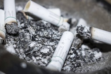 arka plan olarak sigara izmaritleri ve kül görünümünü kapat