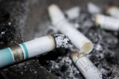 arka plan olarak sigara izmaritleri ve kül görünümünü kapat