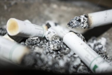 arka plan olarak sigara izmaritleri ve kül görünümünü kapat
