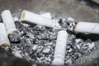 arka plan olarak sigara izmaritleri ve kül görünümünü kapat