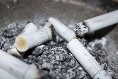 arka plan olarak sigara izmaritleri ve kül görünümünü kapat