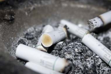 arka plan olarak sigara izmaritleri ve kül görünümünü kapat