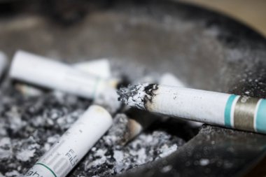 arka plan olarak sigara izmaritleri ve kül görünümünü kapat