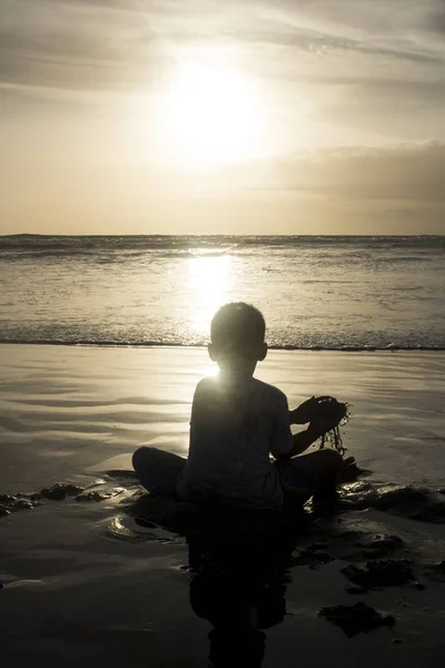 Sylwetka Chłopak Gra Plaży Zachodzącego Słońca Odbijające Się Morze — Zdjęcie stockowe