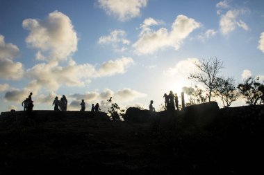 insanlar siluetleri ile mavi bulutlu gökyüzü tepe üzerinde