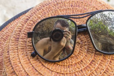 erkek yansıması ile kahverengi kayıkçı şapka ve güneş gözlüğü