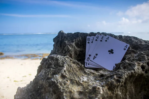 club royal flush poker cards on beach, gamble beach theme