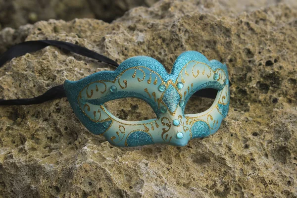 blue glitter masquerade party mask on beach